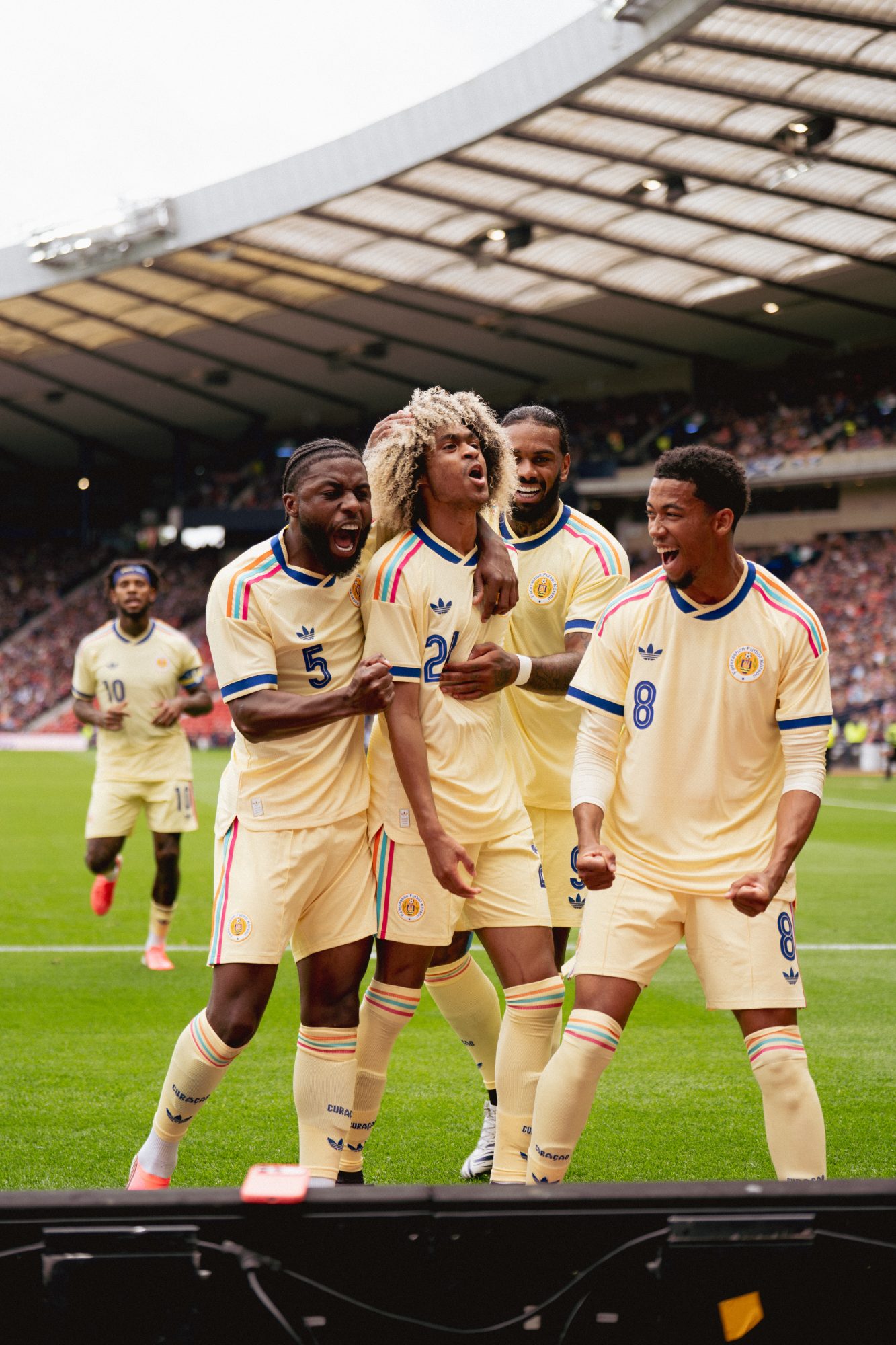 Curacao national team celebrating a goal, match day football photography by TeamWho